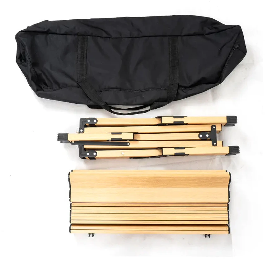 Black carry bag, folded wood-grain X-frame and rolled slatted tabletop arranged for storage